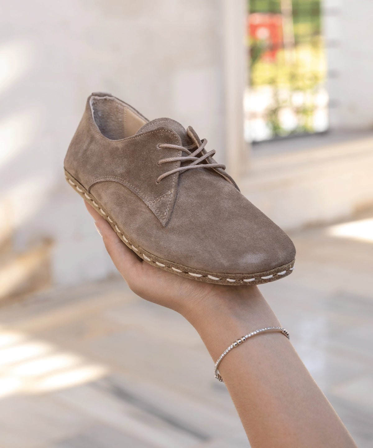 Beige Dawn women's barefoot leather oxford held in hand, sole and stitch detail