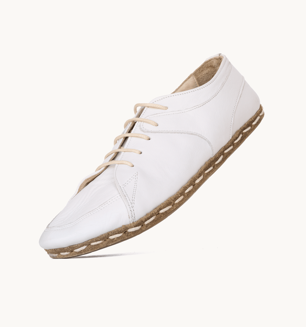 Cloud women's barefoot leather sneaker held in hand, sole and stitch detail
