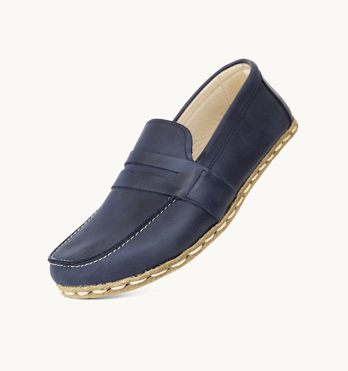 Ocean men's barefoot leather penny loafer held in hand, sole and stitch detail
