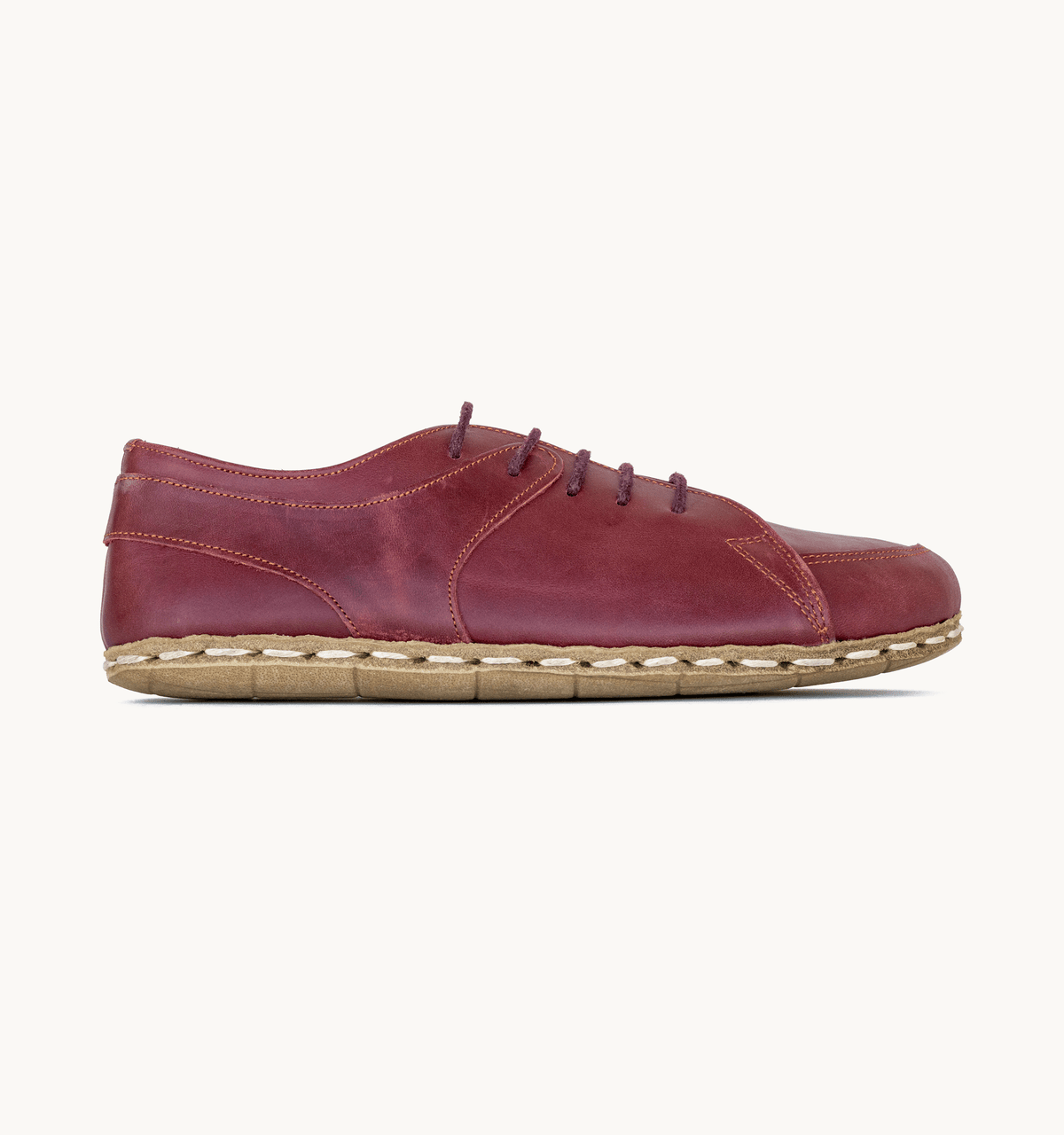Burgundy women's barefoot leather sneaker, side view — hand-stitched, zero drop