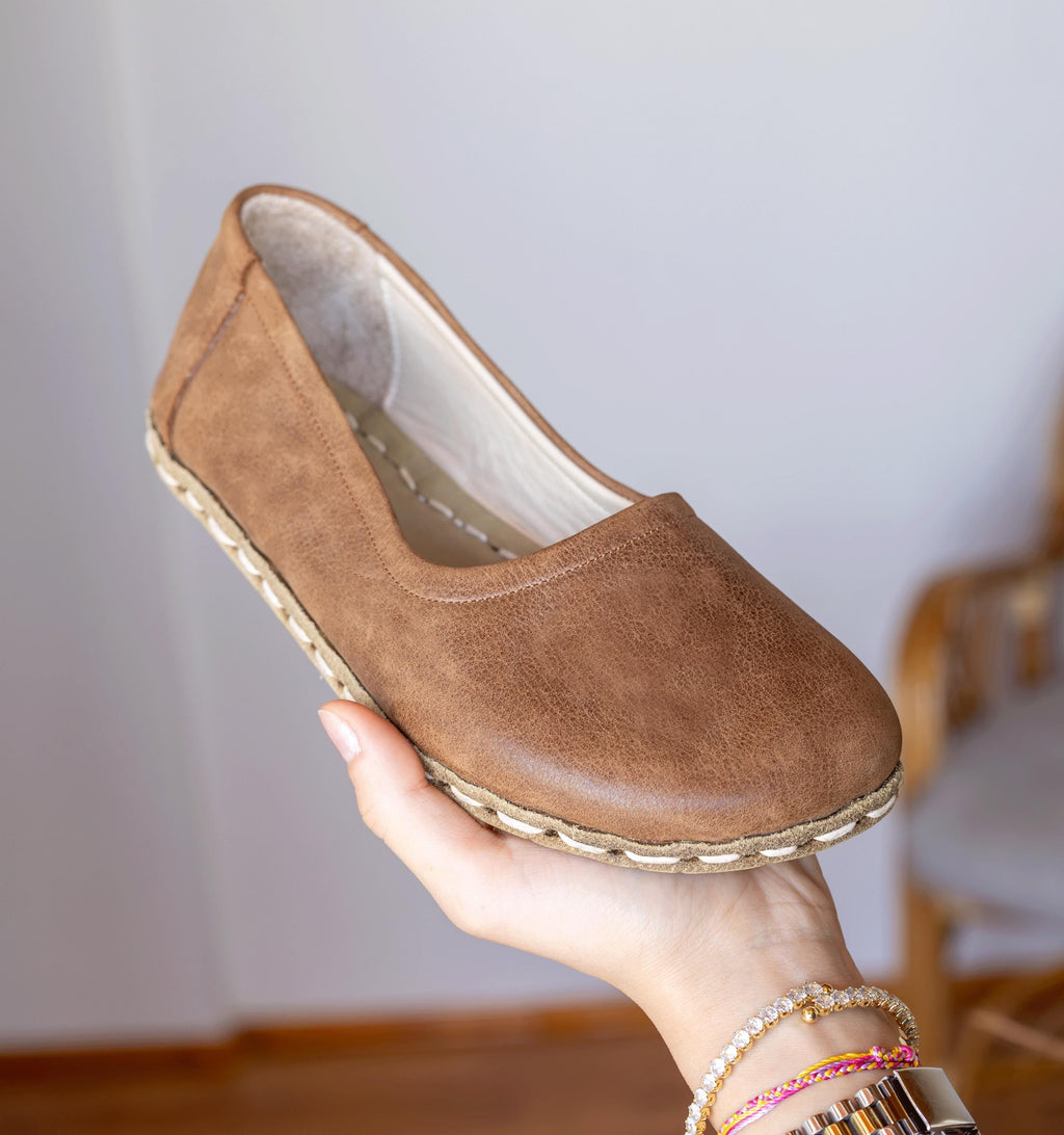 Hickory women's barefoot leather ballet flat held in hand, sole and stitch detail