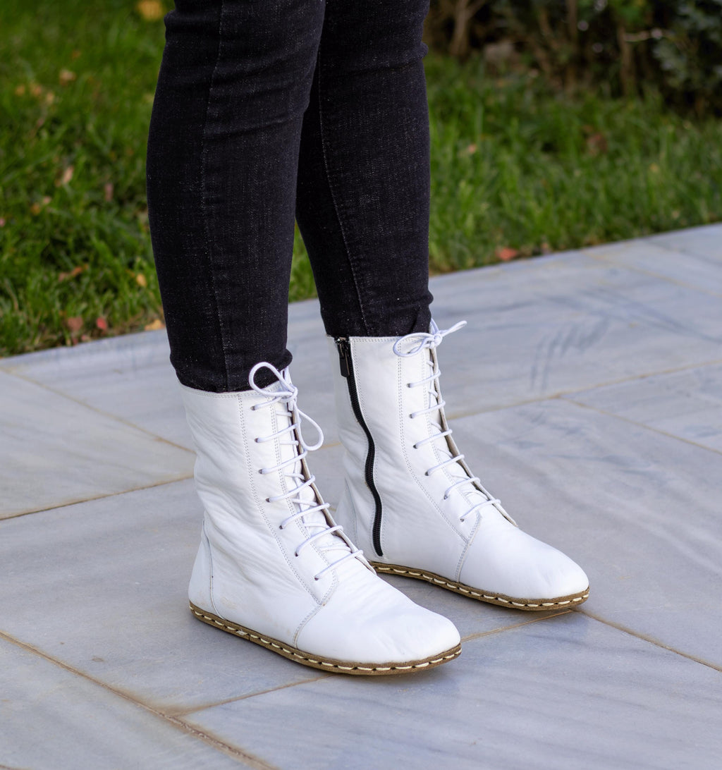 Cloud women's barefoot leather ankle boot held in hand, sole and stitch detail