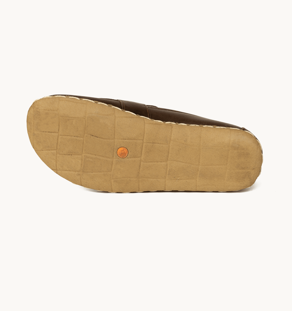 Earth women's barefoot leather penny loafer held in hand, sole and stitch detail