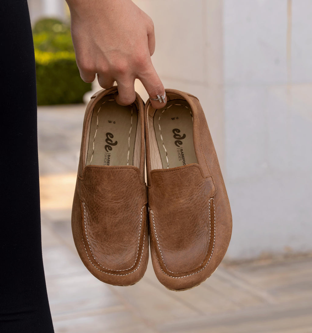 Hickory women's barefoot leather moccasin held in hand, sole and stitch detail
