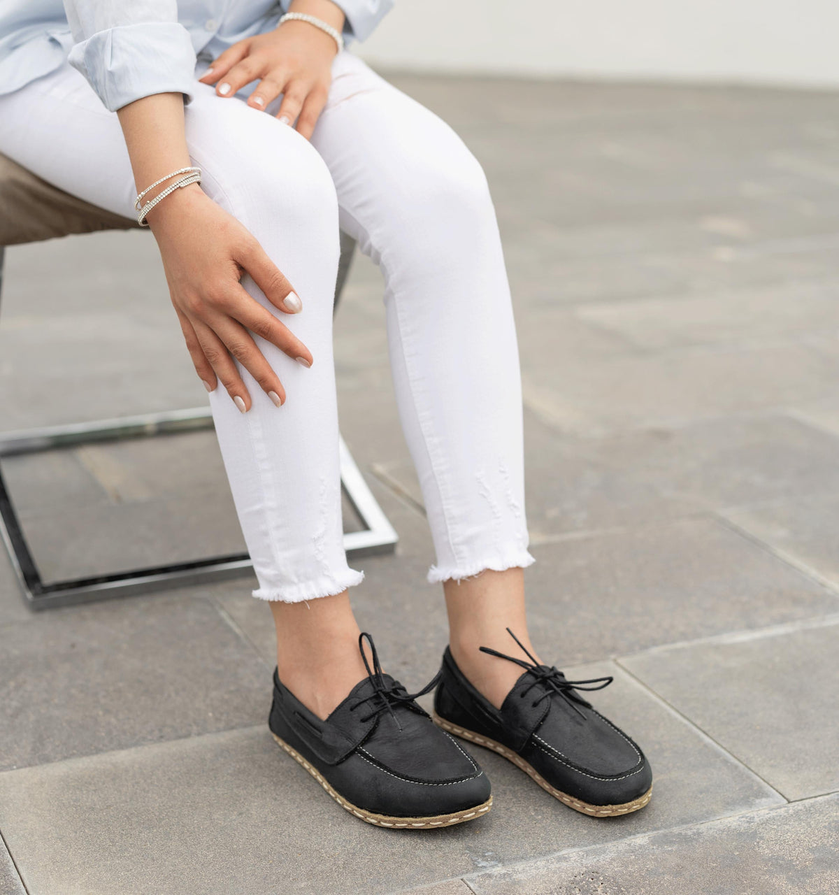 Raven Black women's barefoot leather boat shoe held in hand, sole and stitch detail