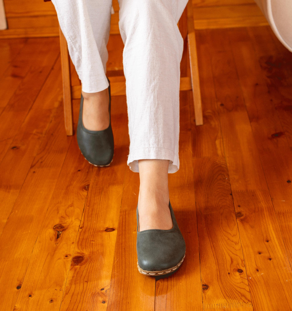 Evergreen women's barefoot leather ballet flat held in hand, sole and stitch detail