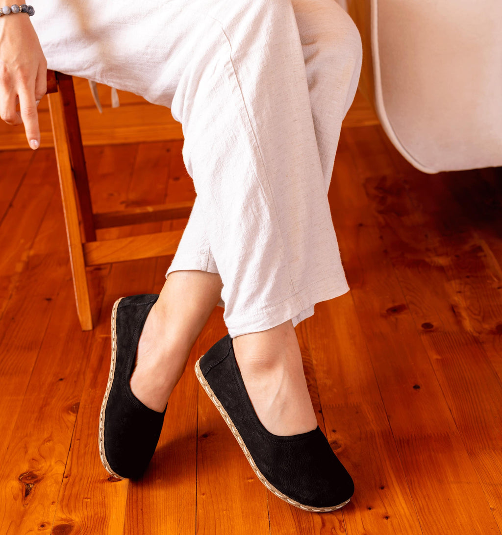 Midnight women's barefoot leather ballet flat held in hand, sole and stitch detail