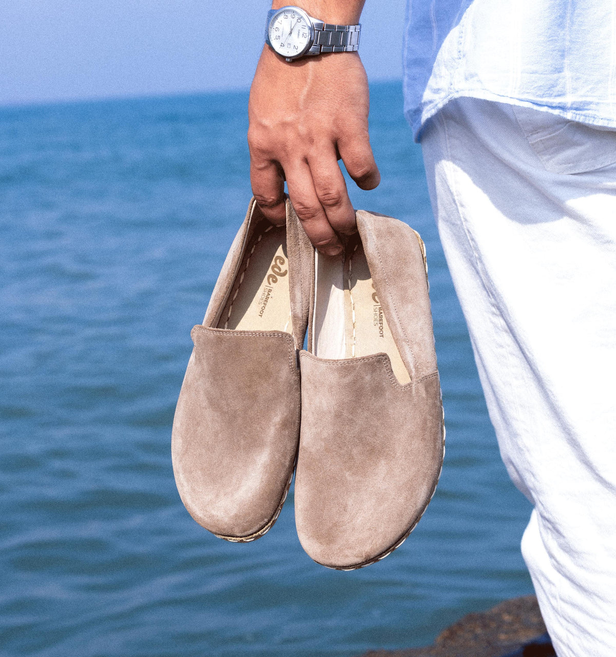 Beige Dawn men's barefoot leather loafer held in hand, sole and stitch detail