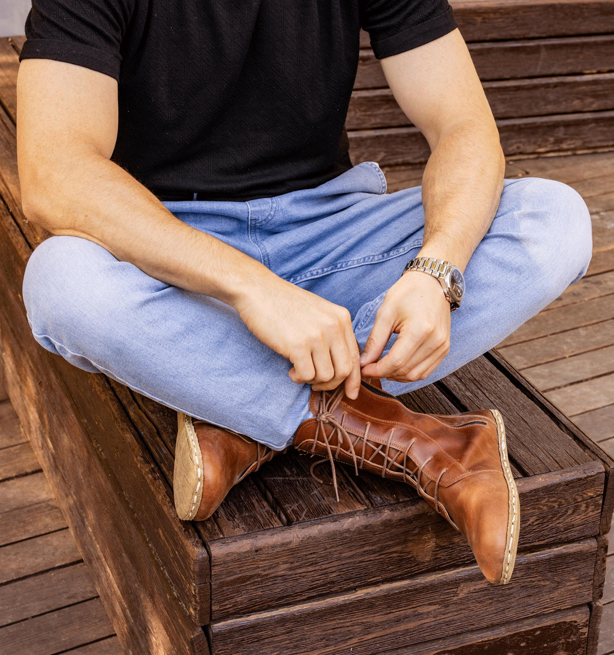 Umber men's barefoot leather ankle boot held in hand, sole and stitch detail