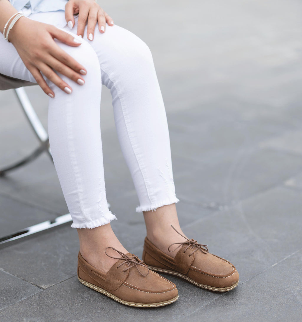 Hickory women's barefoot leather boat shoe held in hand, sole and stitch detail
